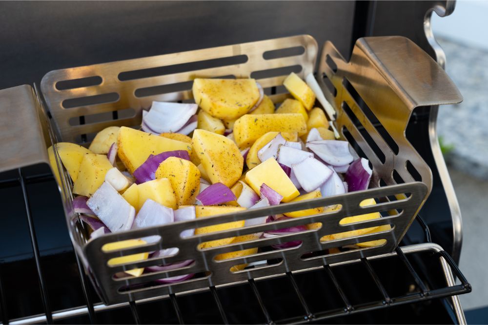 cut potatoes and onions in a grill basket on the grill